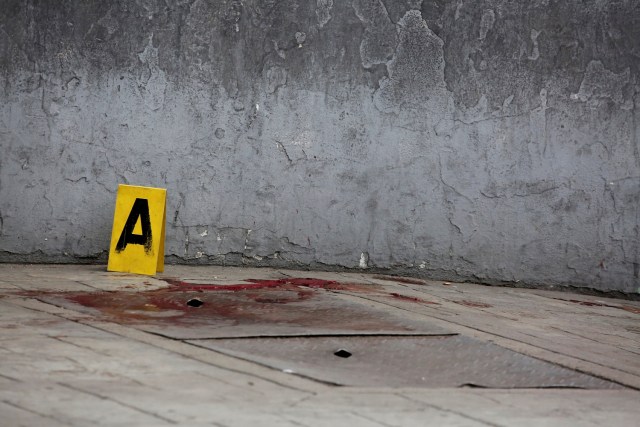 ATTENTION EDITORS - VISUAL COVERAGE OF SCENES OF INJURY OR DEATH  A crime scene marker is seen next to blood after, according to the opposition, gunmen "apparently" shot dead and wounded several people during an opposition-organised unofficial plebiscite against President Nicolas Maduro's government and his plan to rewrite the constitution, in Caracas, Venezuela July 16, 2017. REUTERS/Carlos Garcia Rawlins