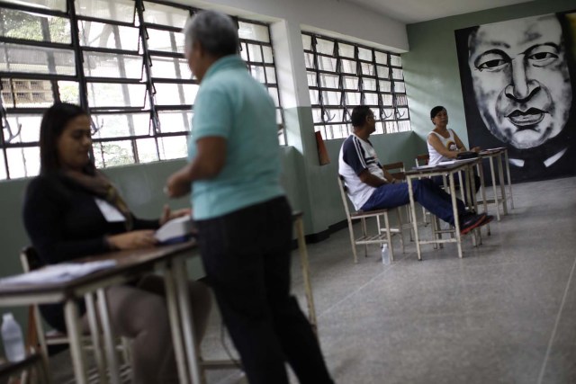 A man shows his identification card to an electoral official before casting his vote at a polling station during the Constituent Assembly election in Caracas, Venezuela, July 30, 2017. REUTERS/Carlos Garcia Rawlins