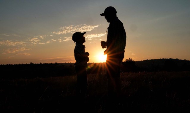 Keobs Avila (R) talks to Sielh Avila at sunrise as they wait for the solar eclipse in Guernsey, Wyoming, U.S. August 21, 2017. REUTERS/Rick Wilking