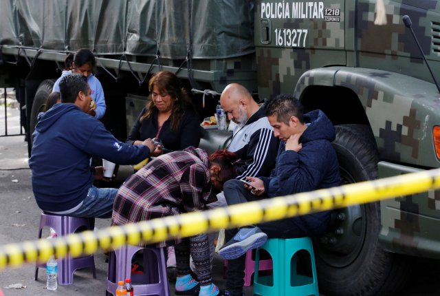 La gente espera noticias de sus seres queridos junto a un edificio derrumbado después de un terremoto en Ciudad de México, México, 23 de septiembre de 2017. REUTERS / Henry Romero