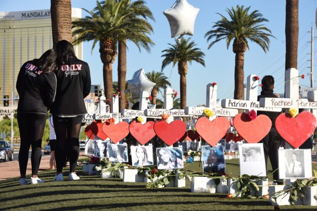 Members of the University of Las Vegas pom squad visit 58 white crosses for the victims of Sunday night's mass shooting on the Las Vegas Strip just south of the Mandalay Bay hotel, October 6, 2017 in Las Vegas, Nevada. On October 1, 2017 Stephen Paddock killed at least 58 people and injured more than 450 after he opened fire on a large crowd at the Route 91 Harvest country music festival. The massacre is one of the deadliest mass shooting events in US history. / AFP PHOTO / Robyn Beck