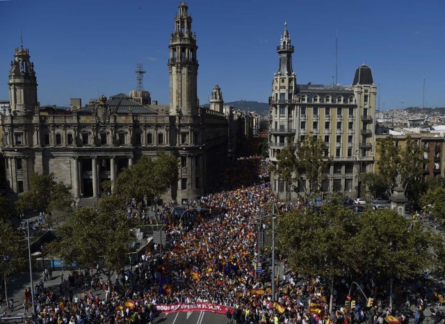 This general view shows protesters holding a banner reading in Catalan "Enough, regain lucidity" during a demonstration called by "Societat Civil Catalans" (Catalan Civil Society) to support the unity of Spain on October 8, 2017 in Barcelona. Spain braced for more protests despite tentative signs that the sides may be seeking to defuse the crisis after Madrid offered a first apology to Catalans injured by police during their outlawed independence vote. / AFP PHOTO / LLUIS GENE