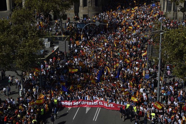 Protester hold a banner reading in Catalan "Enough, regain lucidity" during a demonstration called by "Societat Civil Catalans" (Catalan Civil Society) to support the unity of Spain on October 8, 2017 in Barcelona. Spain braced for more protests despite tentative signs that the sides may be seeking to defuse the crisis after Madrid offered a first apology to Catalans injured by police during their outlawed independence vote. / AFP PHOTO / LLUIS GENE