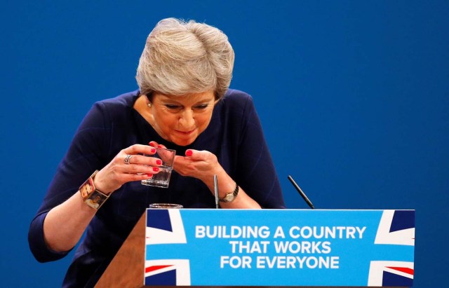 Britain's Prime Minister Theresa May struggles with her glass of water after suffering a coughing fit whilst addressing the Conservative Party conference in Manchester, October 4, 2017. REUTERS/Phil Noble