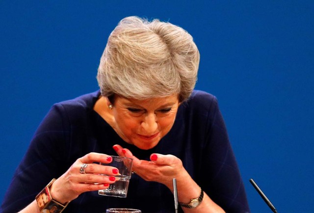 Britain's Prime Minister Theresa May struggles with her water after she suffered a coughing fit whilst addressing the Conservative Party conference in Manchester, October 4, 2017. REUTERS/Phil Noble