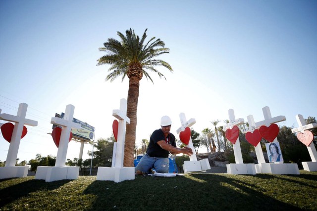 Greg Zanis of Chicago, Illinois works on one of the 58 white crosses he set up for the victims of the Route 91 music festival mass shooting in Las Vegas, Nevada, U.S., October 5, 2017. REUTERS/Chris Wattie TPX IMAGES OF THE DAY