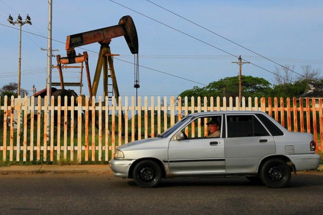 A car drives past a pumpjack in Lagunillas, Venezuela October 5, 2017. Picture taken October 5, 2017. REUTERS/Isaac Urrutia