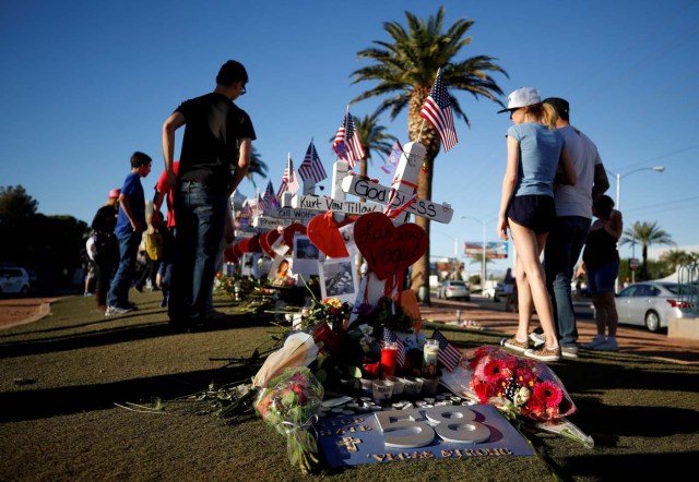 People gather to look at white crosses set up for the victims of the Route 91 Harvest music festival mass shooting in Las Vegas, Nevada, U.S., October 6, 2017. REUTERS/Chris Wattie TPX IMAGES OF THE DAY