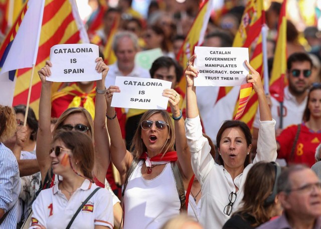 People hold up signs as they attend a pro-union demonstration organised by the Catalan Civil Society organisation in Barcelona, Spain, October 8, 2017. REUTERS/Albert Gea