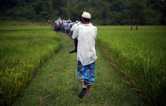 Refugiados rohingya caminan en fila detrás del cadáver de un hombre que fue llevado a su tumba en el campamento de refugiados de Thaingkhali, cerca de Cox's Bazar, Bangladesh, 28 de octubre de 2017. REUTERS / Hannah McKay