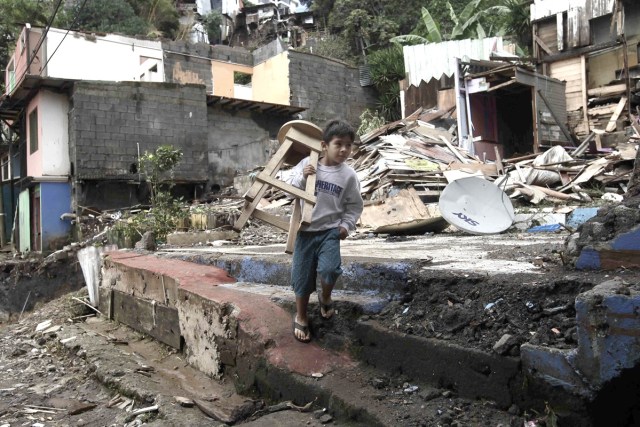 SJS12. SAN JOSÉ (COSTA RICA), 06/10/2017.- Un niño carga una silla en medio de los escombros hoy, viernes 6 de octubre de 2017, en la localidad del Barrio Los Anonos, en el cantón de Escazú, al oeste de San José (Costa Rica), tras el paso de la tormenta tropical Nate. Las autoridades de Costa Rica confirmaron que la cifra de fallecidos a causa de las lluvias provocada por la tormenta tropical Nate ha ascendido hoy a nueve, mientras que hay 25 desaparecidos. La Comisión Nacional de Emergencias (CNE) indicó que hay un total de 7.000 evacuados y han habilitado 95 albergues para las personas que se han visto obligadas a salir de su hogar. EFE/Jeffrey Arguedas