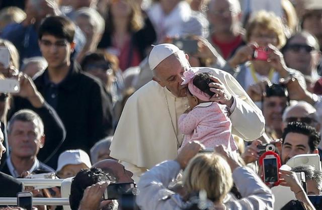El papa Francisco besa a una niña pequeña a su llegada a presidir la audiencia general de los miércoles en la plaza de San Pedro del Vaticano, hoy, 11 de octubre de 2017. EFE/ Fabio Frustaci