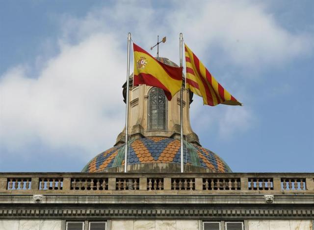 Las banderas española y catalana ondean ondean en la fachada del edificio de la Generalitat de Catalunya en la plaza de Sant Jaume tras la declaración unilateral de independencia ayer en el parlamento autonómico. EFE/ Andreu Dalmau