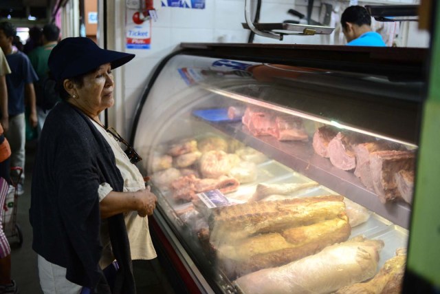 Una mujer compra carne en el mercado municipal de Chacao en Caracas. / AFP PHOTO / FEDERICO PARRA