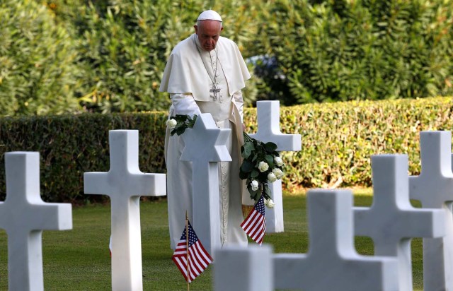 Pope Francis leaves a white rose on the grave of U.S. sergeant Bernard B. Braverman, before a Mass at the U.S. World War II cemetery on the day Christians around the world commemorate their dead, in Nettuno near Rome, Italy, November 2, 2017. REUTERS/Stefano Rellandini