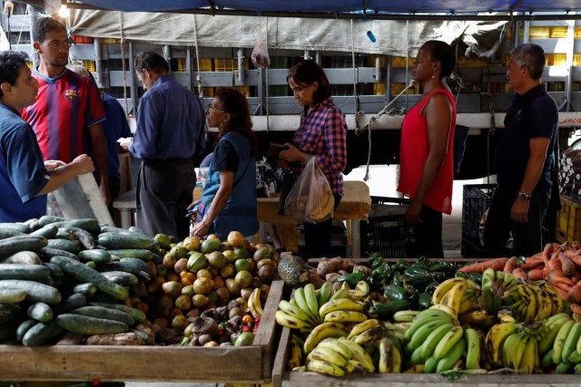 People line up  to pay for their fruits and vegetables at a street market in Caracas, Venezuela November 3, 2017. Picture taken November 3, 2017. REUTERS/Marco Bello