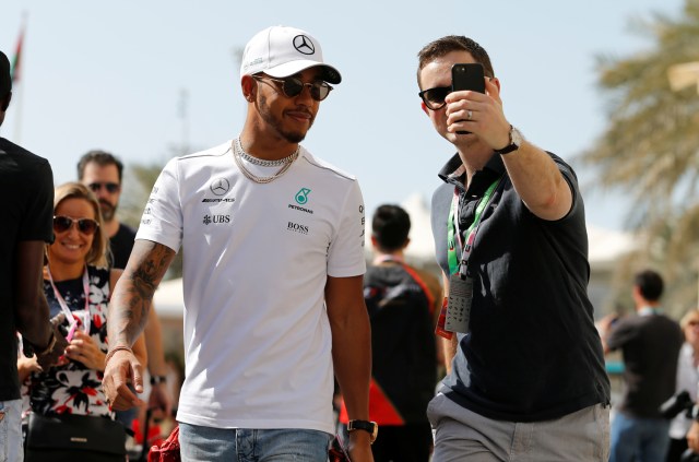 Formula One - F1 - Abu Dhabi Grand Prix - Yas Marina Circuit, Abu Dhabi, United Arab Emirates - November 25, 2017. Mercedes' Formula One driver Lewis Hamilton of Britain takes a selfie with a fan as he arrives at Yas Marina Circuit. REUTERS/Hamad I Mohammed