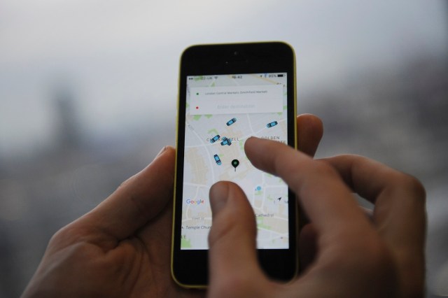 (FILES) This file photo taken on October 28, 2016 shows a man holding a smartphone showing the App for ride-sharing cab service Uber in London. US ride-hailing app Uber on November 10, 2017, lost a landmark case in Britain that would give drivers the right to paid holidays and the national minimum wage, lawyers representing the claimants said. The London employment tribunal rejected Uber's appeal against an October 2016 ruling in a case that is being closely watched for the wider implications for Britain's booming "gig economy". / AFP PHOTO / DANIEL SORABJI