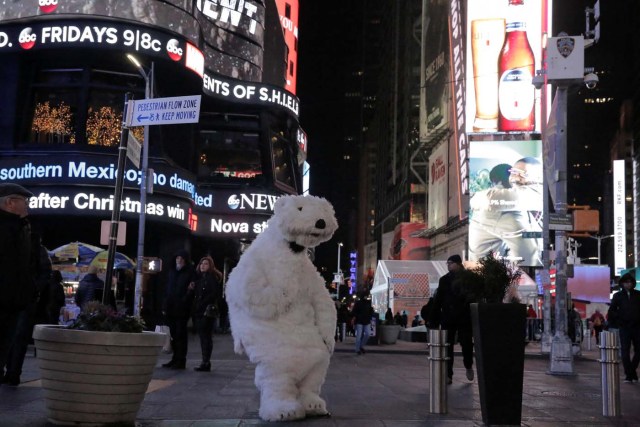 A person dressed in a polar bear costume sits alone on Christmas in Times Square in New York City, New York, U.S., December 25, 2017. Picture taken December 25, 2017. REUTERS/Elizabeth Shafiroff