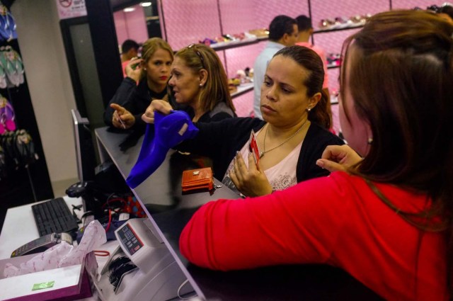 ACOMPAÑA CRÓNICA: VENEZUELA CRISIS - VZL04. CARACAS (VENEZUELA), 15/12/2017.- Fotografía del 14 de diciembre de 2017, de varias mujeres en una tienda de zapatos en Caracas (Venezuela). Los venezolanos podrán disfrutar este año brevemente de sus tradicionales estrenos de ropa, delicias gastronómicas o los juguetes del Niño Jesús como resultado de una situación que tiene a la mayoría de los ciudadanos del país con la soga económica al cuello. Los venezolanos reconocen que este año tendrán que escoger entre una de estas tres tradiciones o reducir el gasto en una de ellas para centrarse en una exclusiva, mientras que los más desfavorecidos no tendrán tanta suerte, a pesar de los bonos y pagas extras que ha empezado a entregar el Gobierno de Nicolás Maduro. EFE/Cristian Hernandez