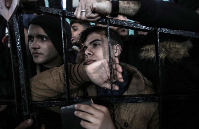 Palestinians wait for permission to cross into Egypt through the Rafah border crossing in the southern Gaza Strip after it was opened by Egyptian authorities on February 21, 2018. Both Israel and Egypt have maintained blockades of Gaza for years, arguing that they are necessary to isolate Hamas. / AFP PHOTO / SAID KHATIB