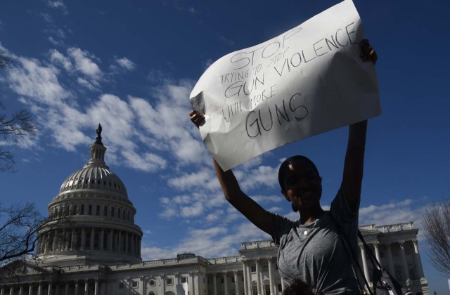 A student hoists a sign as hundreds of high school and middle school students from the District of Columbia, Maryland and Virginia staged walkouts and gather in front of the Capitol in support of gun control in the wake of the Florida shooting February 21, 2018 in Washington, DC. / AFP PHOTO / Olivier Douliery