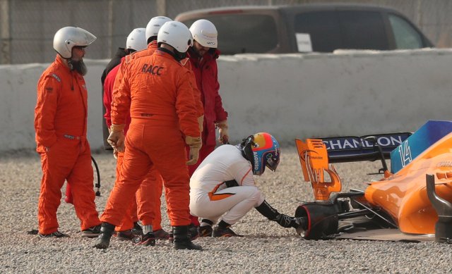 F1 Formula One - Formula One Test Session - Circuit de Barcelona Catalunya, Montmelo, Spain - February 26, 2018 Fernando Alonso of McLaren inspects his car after losing a rear tyre during testing REUTERS/Albert Gea