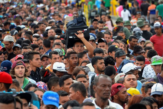 Venezuelan citizens cross the Simon Bolivar international bridge from San Antonio del Tachira in Venezuela to Norte de Santander province of Colombia on February 10, 2018. Oil-rich and once one of the wealthiest countries in Latin America, Venezuela now faces economic collapse and widespread popular protest.  / AFP PHOTO / GEORGE CASTELLANOS