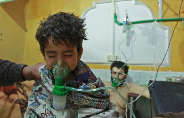 Syrian children and adults receive treatment for a suspected chemical attack at a makeshift clinic on the rebel-held village of al-Shifuniyah in the Eastern Ghouta region on the outskirts of the capital Damascus late on February 25, 2018.   A child died and at least 13 other people suffered breathing difficulties after a suspected chemical attack on the besieged Syrian rebel enclave, a medic and a monitor said. The Britain-based Syrian Observatory for Human Rights said 14 civilians had suffered breathing difficulties after a regime warplane struck the village.   / AFP PHOTO / HAMZA AL-AJWEH