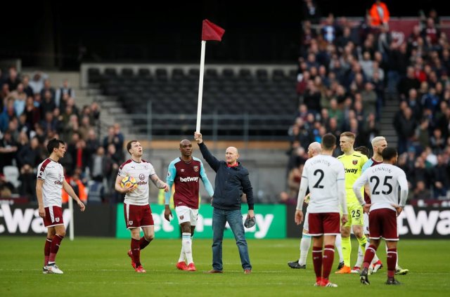 Soccer Football - Premier League - West Ham United vs Burnley - London Stadium, London, Britain - March 10, 2018 Fan holds up a corner flag after invading the pitch REUTERS/David Klein EDITORIAL USE ONLY. No use with unauthorized audio, video, data, fixture lists, club/league logos or "live" services. Online in-match use limited to 75 images, no video emulation. No use in betting, games or single club/league/player publications. Please contact your account representative for further details.
