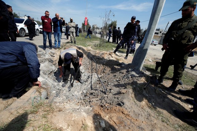 Los palestinos inspeccionan el sitio de una explosión que tuvo como objetivo un convoy que transportaba al primer ministro palestino Rami Hamdallah, en el norte de la Franja de Gaza el 13 de marzo de 2018. REUTERS / Mohammed Salem
