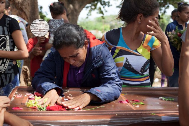 Los deudos lloran junto al ataúd de Edgar Martínez, uno de los reclusos que murió durante un motín y un incendio en las celdas del Comando General de la Policía de Carabobo, durante su funeral en un cementerio de Valencia, Venezuela, el 30 de marzo de 2018. REUTERS / Adriana Loureiro 