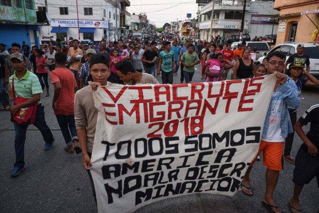 Central American migrants taking part in a caravan called "Migrant Viacrucis" towards the United States hold a banner reading "Emigrant Viacrucis 2018. We are all America. No to discrimination" as they march to protest against US President Donald Trump's policies in Matias Romero, Oaxaca State, Mexico, on April 3, 2018. The hundreds of Central Americans in the "Way of the Cross" migrant caravan have infuriated Trump, but they are not moving very fast -- if at all -- and remain far from the US border. As Trump vowed Tuesday to send troops to secure the southern US border, the caravan was camped out for the third straight day in the town of Matias Romero, in southern Mexico, more than 3,000 kilometers (1,800 miles) from the United States. / AFP PHOTO / VICTORIA RAZO