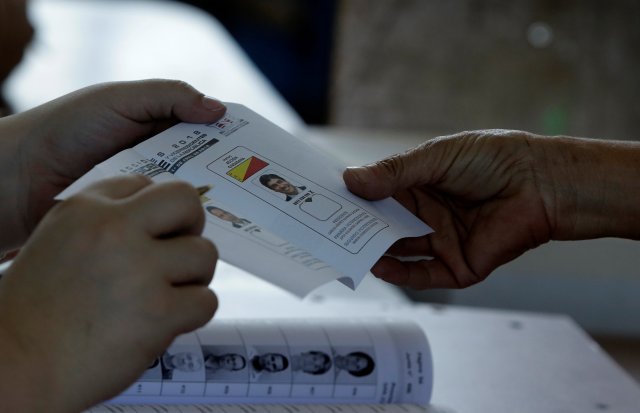 A voter gets a ballot during the presidential election at a polling station in San Jose, Costa Rica, April 1, 2018. REUTERS/Juan Carlos Ulate