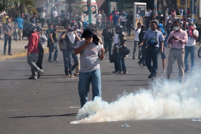 A demonstrator reacts to a tear gas canister during a protest over a controversial reform to the pension plans of the Nicaraguan Social Security Institute (INSS) in Managua, Nicaragua April 20, 2018. REUTERS/Oswaldo Rivas