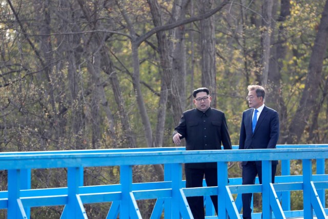 South Korean President Moon Jae-in and North Korean leader Kim Jong Un walk together on a bridge at the truce village of Panmunjom inside the demilitarized zone separating the two Koreas, South Korea, April 27, 2018. Korea Summit Press Pool/Pool via Reuters