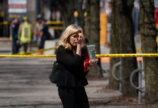 A pedestrian walks along a police crime scene tape near where a van struck multiple people at a major intersection in Toronto's northern suburbs in Toronto, Ontario, Canada, April 23, 2018. REUTERS/Carlo Allegri