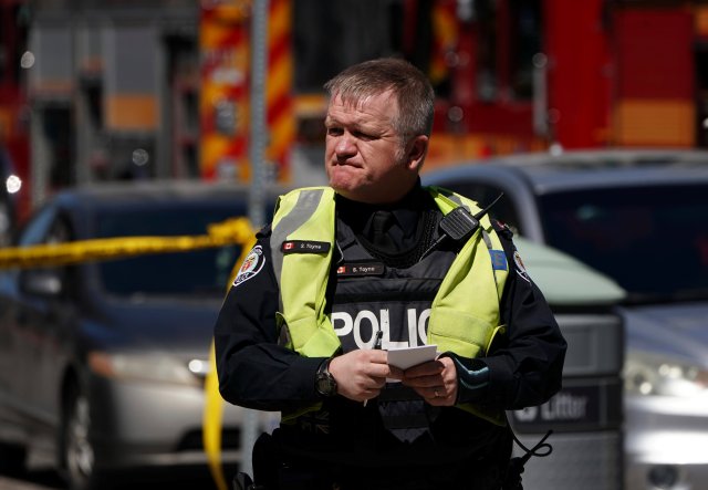 A police officer responds to an incident where a van struck multiple people at a major intersection in Toronto's northern suburbs in Toronto, Ontario, Canada, April 23, 2018. REUTERS/Carlo Allegri