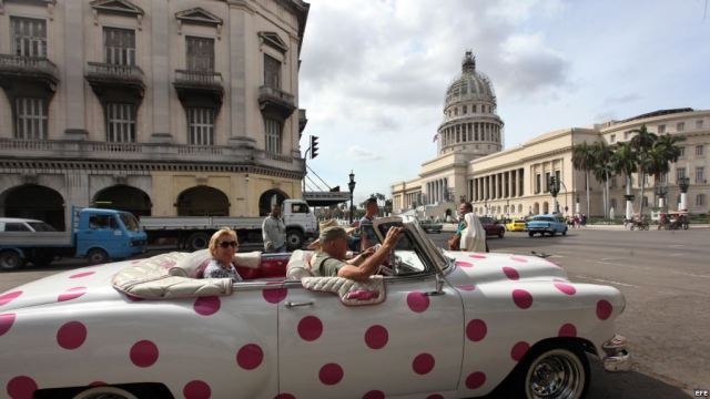 Turistas se pasean en un auto clásico cerca del Capitolio, en La Habana. (Archivo)