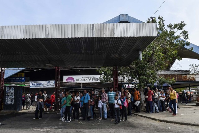 People wait for a transport in Maracaibo, Venezuela, on May 2, 2018. Amid blackouts, skyrocketing prices, shortage of food, medicine and transportation, Venezuelans go to elections next May 20 anguished to survive one of the worst crisis in the oil country. / AFP PHOTO / Federico PARRA