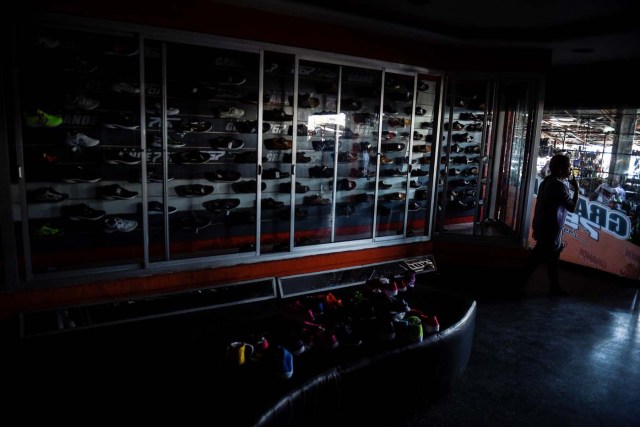 A man walks inside a store during a power outage in Maracaibo, Venezuela on May 3, 2018. Amid blackouts, skyrocketing prices, shortage of food, medicine and transportation, Venezuelans go to elections next May 20 anguished to survive one of the worst crisis in the oil country. / AFP PHOTO / Federico PARRA