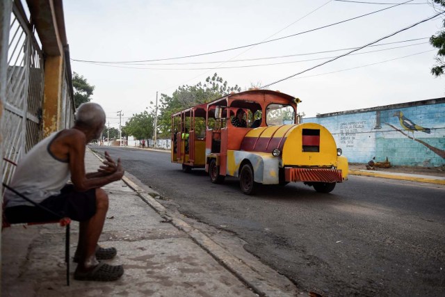 People travel in a children's train due to the lack of public transport on May 2, 2018, in Maracaibo, Venezuela. Amid blackouts, skyrocketing prices, shortage of food, medicine and transportation, Venezuelans go to elections next May 20 anguished to survive one of the worst crisis in the oil country. / AFP PHOTO / Federico PARRA