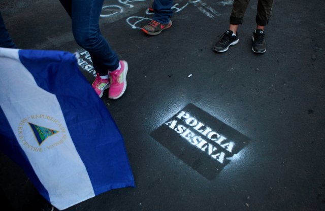 Los manifestantes caminan junto a un graffiti que dice "Policía asesina" durante una protesta contra el gobierno del presidente de Nicaragua, Daniel Ortega, en Managua, Nicaragua, el 15 de mayo de 2018. REUTERS / Oswaldo Rivas