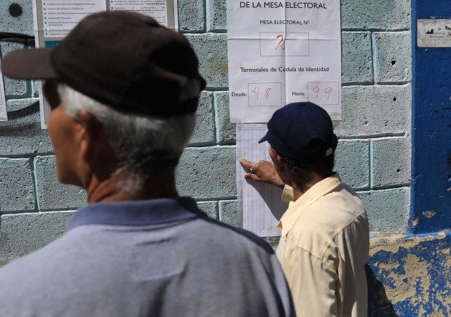 Venezuelan citizens check electoral lists at a polling station during the presidential election in Caracas, Venezuela, May 20, 2018. REUTERS/Marco Bello