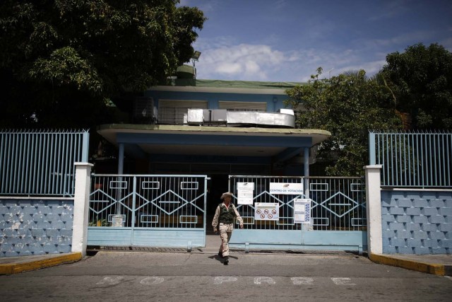 A militia member stands guard at a polling station during the presidential election in Caracas, Venezuela, May 20, 2018. REUTERS/Carlos Garcia Rawlins