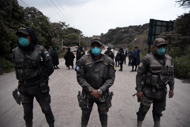 Los oficiales de policía están apostados en el municipio de Alotenango, departamento de Sacatepequez, a unos 65 km al suroeste de Ciudad de Guatemala, mientras el Volcán de Fuego entra en erupción el 3 de junio de 2015. / AFP PHOTO / ORLANDO ESTRADA