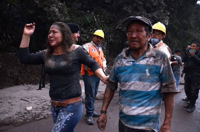 Personas huyen de la aldea El Rodeo, departamento de Escuintla, a 35 km al sur de Ciudad de Guatemala, luego de la erupción del volcán de Fuego el 3 de junio de 2018. / AFP PHOTO / NOE PEREZ 