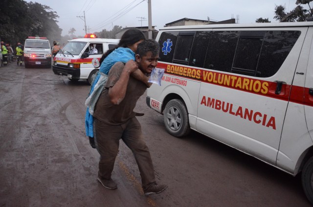 Personas huyen de la aldea El Rodeo, departamento de Escuintla, a 35 km al sur de Ciudad de Guatemala, luego de la erupción del volcán de Fuego el 3 de junio de 2018. / AFP PHOTO / NOE PEREZ
