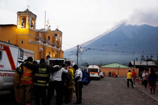 Los bomberos rezan después de que el volcán Fuego erupcionó violentamente en San Juan Alotenango, Guatemala el 3 de junio de 2018. REUTERS / Luis Echeverría