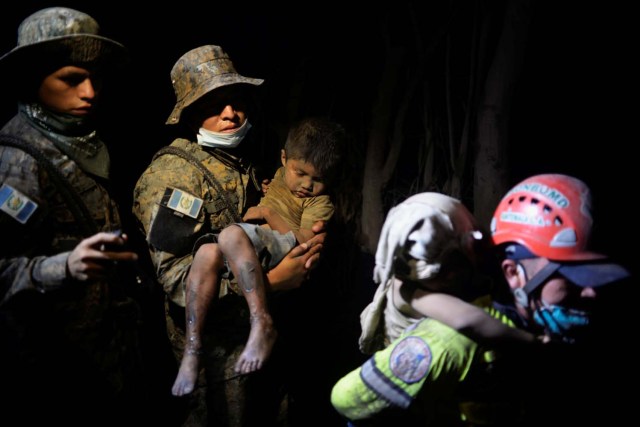 EDITORES DE ATENCIÓN - COBERTURA VISUAL DE ESCENAS DE MUERTE O LESIÓN Un soldado lleva a un niño rescatado cubierto de cenizas a un hospital después de que el volcán Fuego estalló violentamente en El Rodeo, Guatemala el 3 de junio de 2018. REUTERS / Fabricio Alonzo